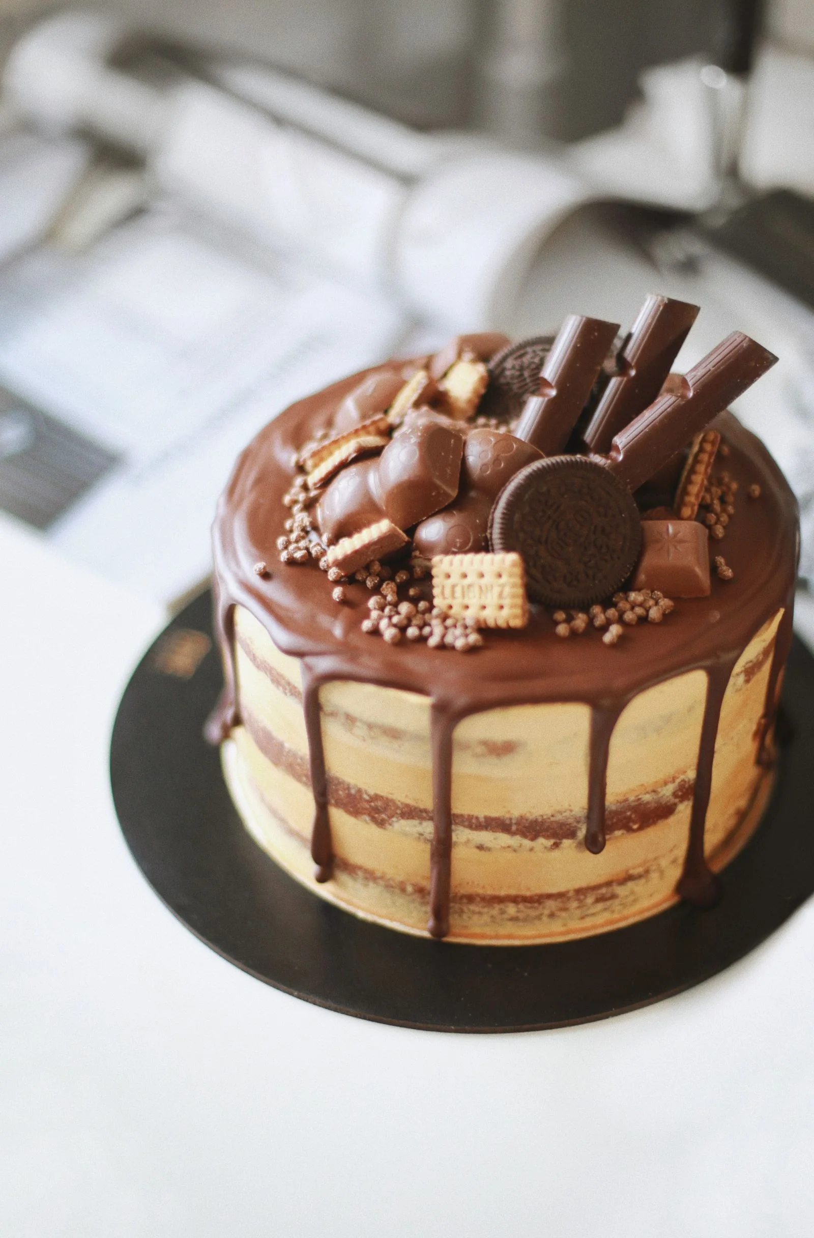 Chocolate drip cake decorated with chocolate and biscuits — editorial reference photograph