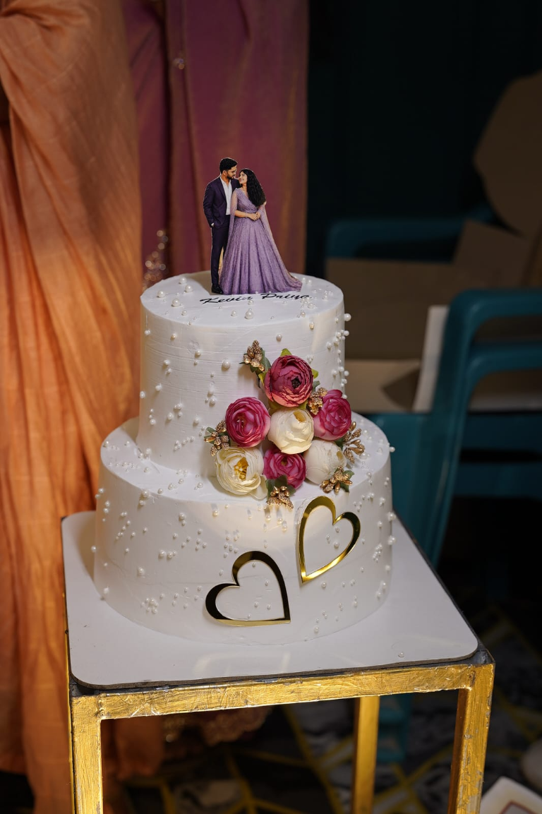 Kevin's wedding cake decorated with flowers and a couple topper